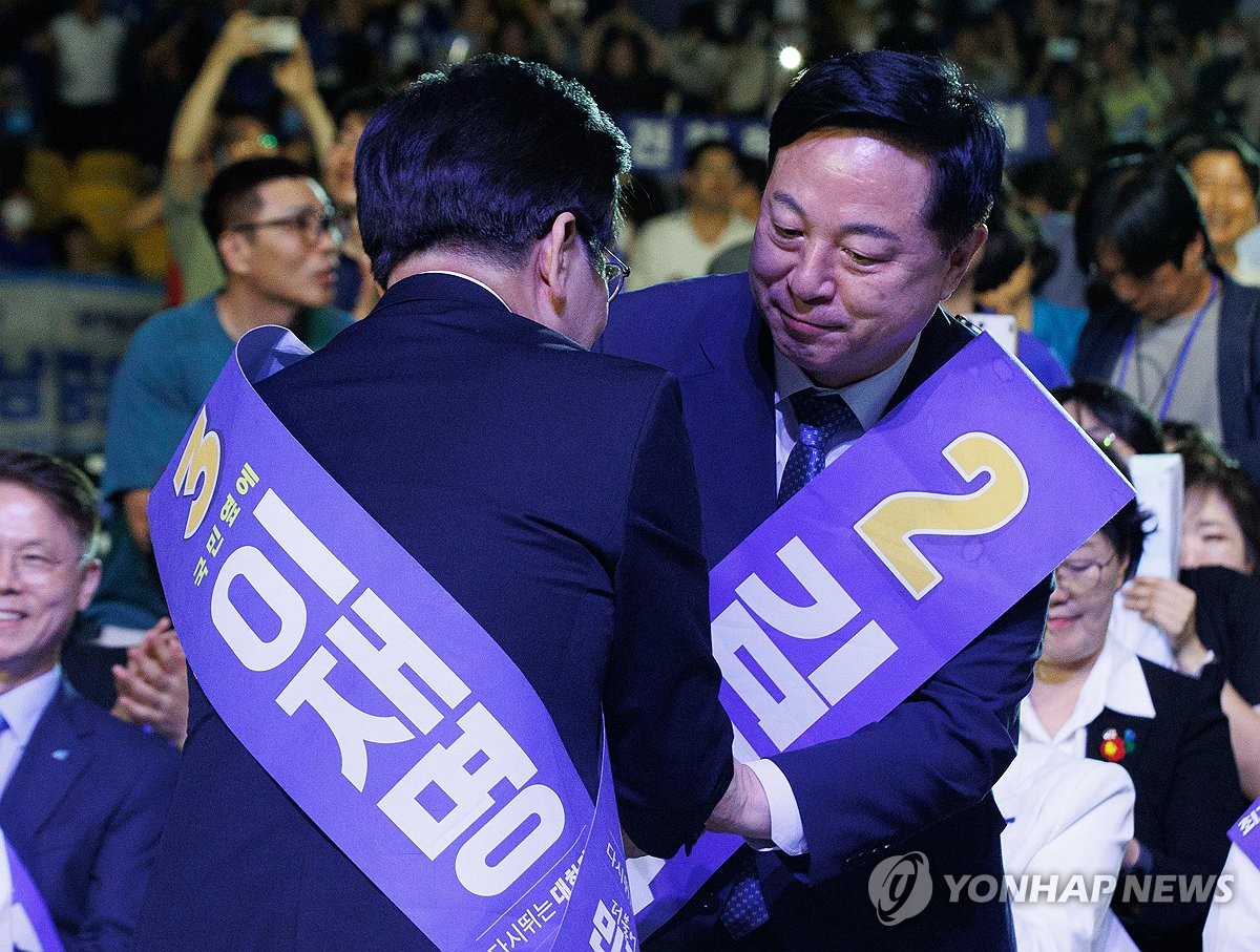 지난해 8월 민주당 전당대회에서 김두관 후보에게 축하 인사받는 이재명 대표